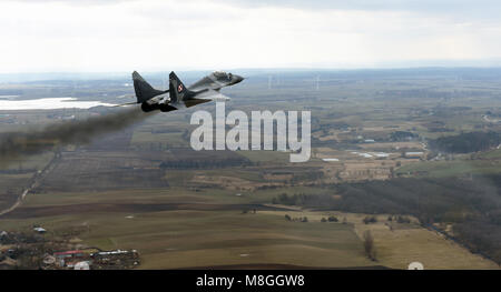 Eine polnische Luftwaffe MiG-29 Fighter beschleunigt und steigt bei einem Formationsflug mit US Air Force C-130 Hercules aus der 182 Luftbrücke Flügel im Norden Polens, 15. März 2018. Rund 70 Flieger und drei C-130 s aus der 182 Luftbrücke Flügel sind die Teilnahme an bilateralen Training mit der polnischen Luftwaffe während der Luftfahrt Rotation 18-2 zur Unterstützung der Operation Atlantic lösen. Diese Ereignisse treten in den USA die europäischen Befehl Verantwortungsbereich und sind so konzipiert, dass Partner, die Interoperabilität zu verbessern, pflegen die gemeinsame Bereitschaft, und unsere Verbündeten in der Region zu gewährleisten. (U.S. Air National G Stockfoto