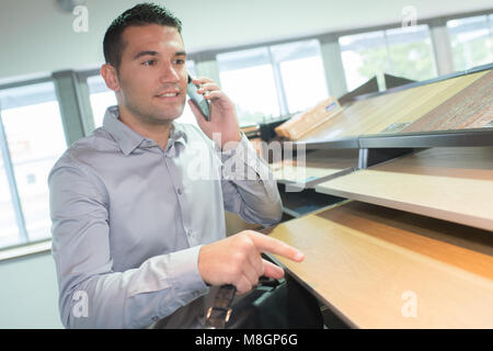 Lächelnd gutaussehenden männlichen Designer über Mobiltelefon im Studio Stockfoto