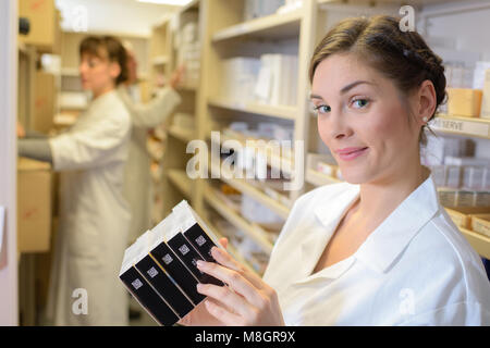 Schöne junge weibliche Apotheker holding Medizin Boxen Stockfoto