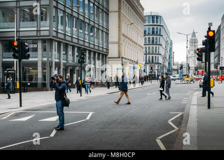 London, Großbritannien, 13. März 2018: Junger Mann mit einer professionellen Kamera auf der Mitte der Straße in der City von London, England, Großbritannien Stockfoto