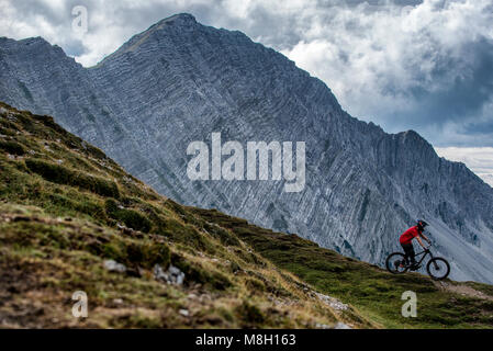Ein Mountainbiker Fahrten entlang einer Kante in die Österreichische Alpine Resort von Lermoos. Stockfoto