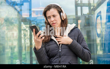 Eifersucht und Argwohn in das Handy, ein paar Probleme, erwachsene Frau suchen, auf verdächtige Nachrichten auf dem Telefon, während auf der Straße hören mu Stockfoto