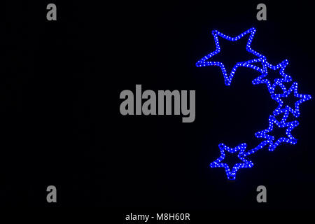 Gold Gewinner Auszeichnung mit drei Sternen auf den ersten Platz in einem Wettbewerb oder Meisterschaft stehen auf einem Podest vor einem blauen Hintergrund zu vergeben. Stockfoto