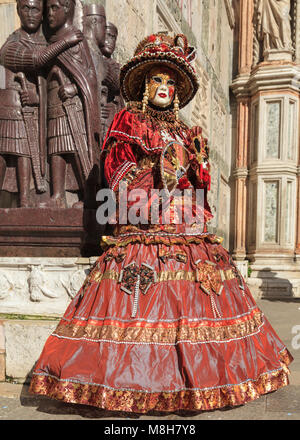 Frau in wunderschönen historischen venezianischen Kostümen posiert auf vier Tetrarchen Statuen, Markusplatz, Venedig, Karneval, di Venezia, Italien Stockfoto