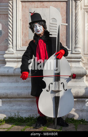 Ein pierrot oder Pierot trauriger Clown aus der Commedia dell'arte in schickes Kleid Kostüm, spielt eine Basis am Karneval in Venedig, Carnivale di Venezia, Italien Stockfoto