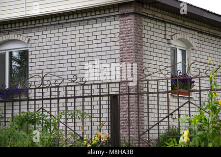 Gemütliches Haus mit schönen Garten- und Landschaftsbau an einem sonnigen Tag. Home Exterieur Stockfoto