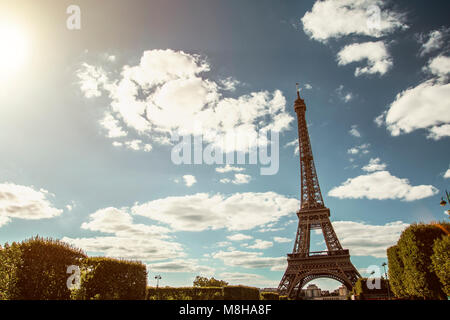 Blick auf den wunderschönen Eiffelturm unter grünen üppigen Bäumen im Sommer auf dem Hintergrund des blauen Himmels Stockfoto