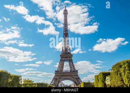 Blick auf den wunderschönen Eiffelturm unter grünen üppigen Bäumen im Sommer auf dem Hintergrund des blauen Himmels Stockfoto