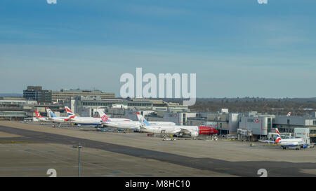 London Gatwick, 15. März 2018: Flugzeuge verschiedener Flugzeuge auf Asphalt warten auf Passagiere am Londoner Flughafen Gatwick North Terminal Stockfoto