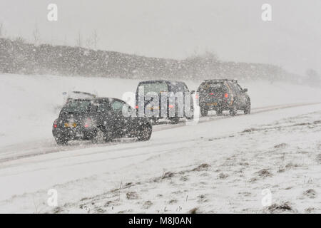 Lange Bredy, Dorset, Großbritannien. 18. März 2018. UK Wetter. (Reihenfolge der Bilder eines Unfalls 1 von 5) ein Auto zieht auf der Straße und schlägt die Leitplanken in der zentralen Reservierung, da der Fahrer nicht in der Lage ist, zu stoppen, stationäre Autos, Blizzard Bedingungen auf der A35 bei langen Bredy zwischen Bridport und Dorchester, Dorset als schwerer Schnee, der die Straße abgedeckt hat aufgehört haben zu vermeiden, macht das Fahren gefährlich. Foto: Graham Jagd-/Alamy Leben Nachrichten. Stockfoto