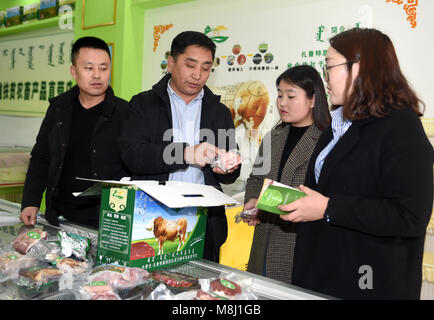 (180318) - Peking, 18. März 2018 (Xinhua) - Wu Yunbo (2. L) stellt Rindfleischerzeugnissen seiner Genossenschaft zu Kunden in einem Geschäft in Lubei Township von Jarud Qi (Grafschaft), North China Autonome Region Innere Mongolei, Feb 26, 2018. Wu Yunbo der Mongolei ethnische Gruppe kommt aus Dongsala Dorf Jarud Qi (County) der Norden Chinas Autonome Region Innere Mongolei. Als Sekretär der Kommunistischen Partei von China Niederlassung im Dongsala Dorf, initiierte er eine Genossenschaft in 2013 und untersucht die Art und Weise, wie die Menschen aus der Armut zu erhalten. Bauern und Hirten wurden ermutigt die Cooperativ beitreten Stockfoto