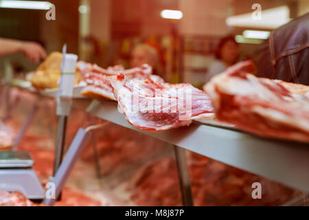 Metzger schneidet ein Stück Fleisch auf dem Markt die Hände eines Metzgers schneiden Scheiben von rohem Fleisch Stockfoto