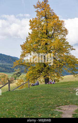 BANSKA STIAVNICA, SLOWAKEI - 28. SEPTEMBER 2017: Unerkannte Touristen Rest unter einem Herbst Baum auf Golgatha. Dieser Kreuzweg ist ein Komplex aus 3 Kirchen ein Stockfoto