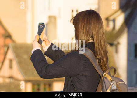 Eine junge Frau, ein Foto mit Ihrem Smartphone am späten Nachmittag in Straßburg, Frankreich. Stockfoto