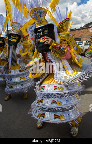 Close-up des Menschen in traditionellen Kostümen, Masken und Kopfschmuck in Gelb und Weiß, Festival Parade Stockfoto