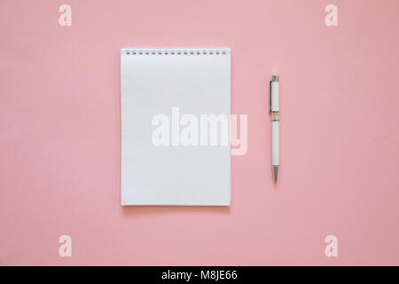 Blick von oben auf die leere Notiz Papier mit Stift auf rosa Hintergrund Stockfoto