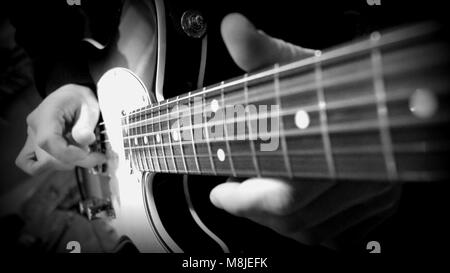 Schwarz & Weiß Nahaufnahme einer E-Gitarre gespielt wird Stockfoto