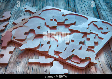 Unvollständige Puzzles auf hölzernen Tisch Hintergrund. closeup. Puzzles auf Holztisch, aus der Nähe. Stockfoto