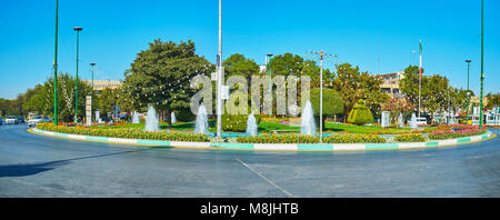 ISFAHAN, IRAN - Oktober 20,2017: Der malerische Garten mit getrimmten Bäumen und Blumenbeeten in der Mitte des Enghelab Square entfernt und umgeben von Quelle Stockfoto