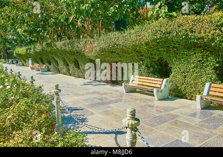 Die schöne Gasse in Hasht Behesht Garten mit üppiger Bäume, getrimmt, Büsche, Beete mit Rosen, Isfahan, Iran. Stockfoto