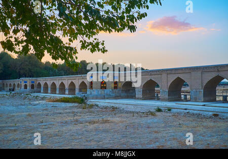 Die angenehmen Abendspaziergang im Riverside Park mit Blick auf den mittelalterlichen gewölbten Joui Brücke und ausgetrockneten Zayanderud, Isfahan, Iran. Stockfoto