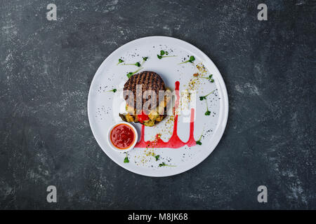 Gegrilltes Schnitzel aus Kalbfleisch mit gegrilltem Gemüse und Sauce mischen. Stockfoto