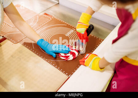 Lollipop Vorbereitung, Kind macht Karamellbonbons in der Werkstatt. Urlaub in Candy Store Stockfoto