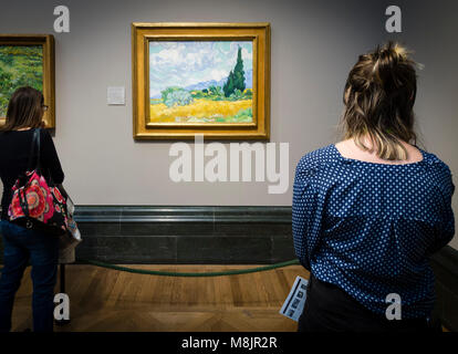 London, Großbritannien - 1 May 2017: Besucher des Londoner National Gallery sehen Vincent van Goghs berühmten Öl Gemälde "EIN Wheatfield, mit Zypressen. Stockfoto