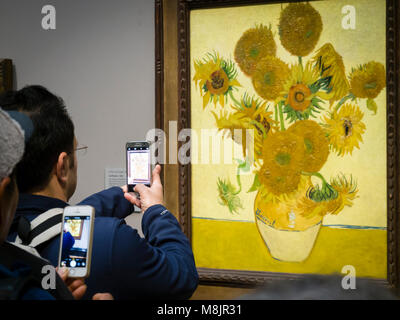 London, Großbritannien - 30 Dez 2017: Besucher der Londoner National Gallery werden über ihre Smartphones Bilder von Vincent van Gogh's Öl Malerei unflowers', eines der bekanntesten Exponate des Museums. Stockfoto