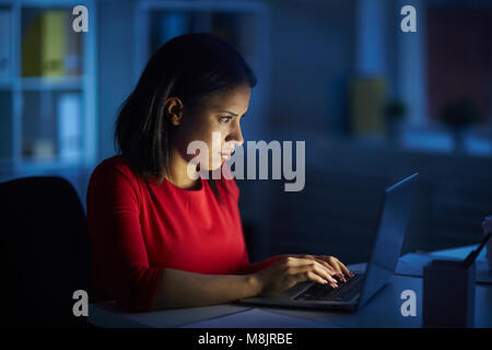 Junge manager Sitzen an Ihrem Arbeitsplatz und Tippen auf Laptop Stockfoto