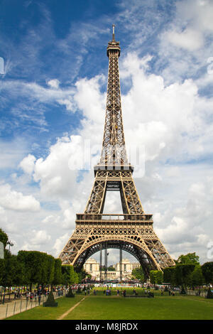 Eine vertikale, volle Länge Blick auf den Eiffelturm in Paris, Frankreich suchen Golden im Sommer mit blauem Himmel und weißen Wolken. Stockfoto