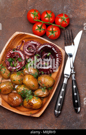 Gegrillter Tintenfisch mit kleinen Kartoffeln mit Kräutern und Gewürzen. Ansicht von oben Stockfoto
