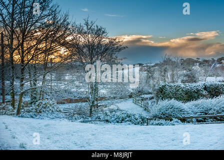 Die Sonne über den Bauernhof auf dem Hügel. Ein herrlicher Morgen ein kalter Dezember Tag willkommen zu heißen. Stockfoto