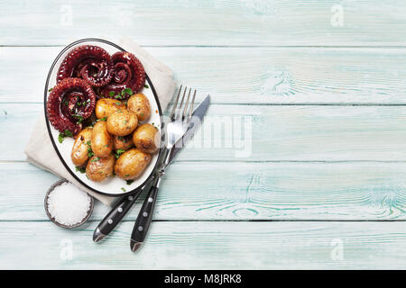 Gegrillter Tintenfisch mit kleinen Kartoffeln mit Kräutern und Gewürzen. Ansicht von oben mit Platz für Ihren Text Stockfoto