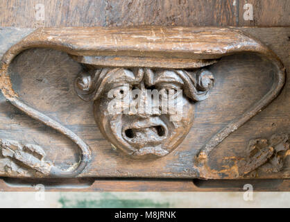 Misericord mit dem Schnitzen von offenen Mündern männlichen Kopf. St. Cuthbert Kirche Holme Lacy Herefordshire UK. März 2018. Stockfoto