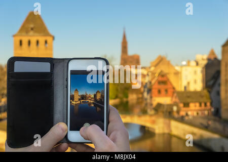 Nahaufnahme eines Smartphone verwendet ein Bild des Stadtbildes von Straßburg mit der Kathedrale Unserer Lieben Frau, Straßburg, Frankreich zu nehmen. Stockfoto
