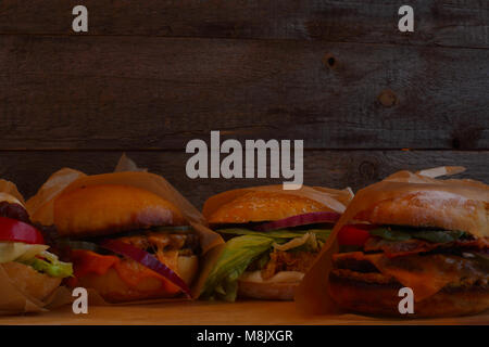 Viele große frische leckere Burger auf dunklem Hintergrund mit Platz für Text kopieren Stockfoto