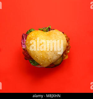 Herzförmige hamburger, liebe Burger fast food Konzept, auf rotem Hintergrund, Ansicht von oben Stockfoto