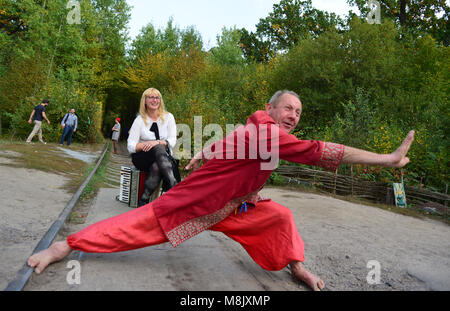 Ein Mann in Volkskleidung, der Besucher in der Nähe des Tunnels der Liebe in der Nähe von Rivne, Ukraine, unterhält Stockfoto