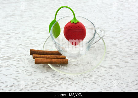 Leere Teetasse mit Silikon Tea Leaf Filter in Erdbeere geformt und Zimt Stockfoto
