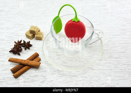 Leere Teetasse mit Silikon Tea Leaf Filter in Erdbeere geformt, Würfelzucker, Zimt und Sternanis Stockfoto