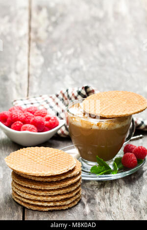 Stapel von Niederländischen karamell Waffeln mit frischen Himbeeren und Tasse Kaffee Stockfoto