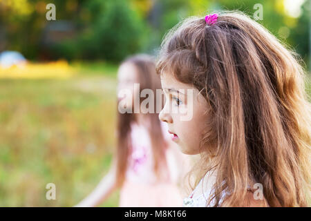 Wunderschöne kleine Mädchen mit langen lockigen Haar, auf der Suche nach Sommer Tag besorgt. Für text Stockfoto