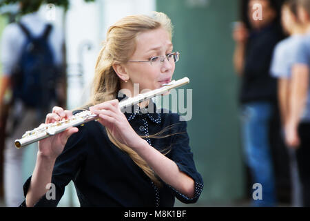 Belarus, Gomel, 16. September 2017. Feiert die Stadt Tag. Der Musiker spielt die Flöte. Ein junges Mädchen bläst eine Flöte. Spielen der Querflöte Stockfoto