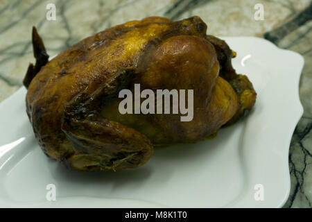Gebackene ganzes Huhn mit Pilzen und Kartoffeln close-up auf einem Teller auf dem Tisch. Senkrechte Draufsicht von oben Stockfoto