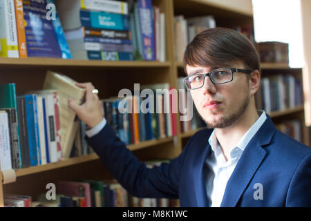 Belarus, Gomel, 19. September 2017. Die hauptbibliothek. Der Tag der offenen Türen. Eine intime Mann mit Brille in der Bibliothek. Schüler in der Bibliothek Stockfoto