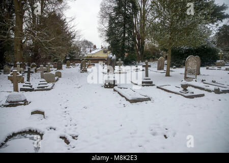 In der winterlichen Szene, die als Mini-Biest aus dem Osten bezeichnet wird, sind in Snow in Bekshire Grabsteine zu sehen, die Großbritannien im Griff behalten. Stockfoto