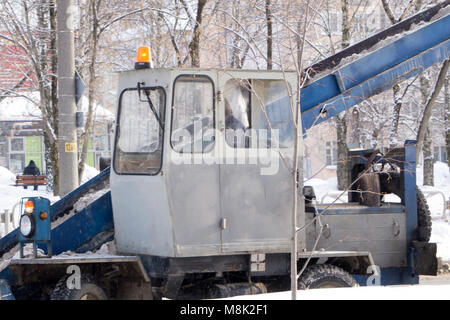 Traktor Reinigung der Straße vom Schnee. Bagger säubert die Straßen von großen Mengen an Schnee in der Stadt. Die Arbeiter von der Straße fegen Schnee im Winter, Cleani Stockfoto