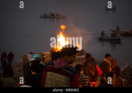 VARANASI, Indien. 28. Februar 2017: Die Menschen auf dem Scheiterhaufen sehen, die Nacht. Die Zeremonie der Einäscherung von Manikarnika Ghat am Ufer des Stockfoto