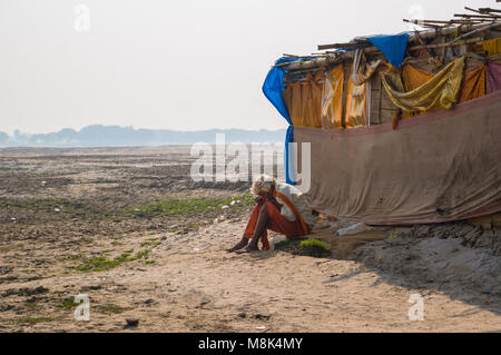 VARANASI, Indien. Februar 28, 2017: Der Einsiedler, ein Sadhu, sitzt das Meditieren über das Gegenteil der Varanasi Ufer des heiligen Flusses Ganges Stockfoto